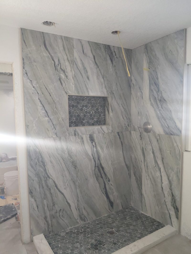 White marble-look tile shower with a built-in niche