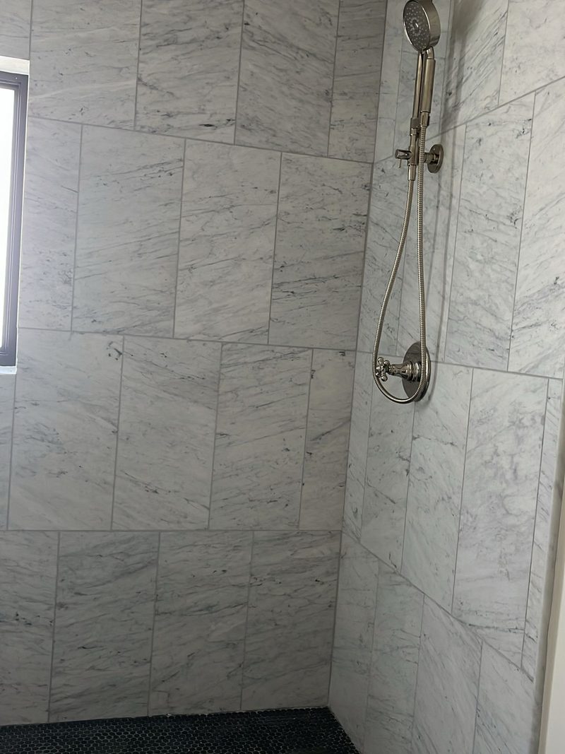 Large-format marble-look tile shower walls