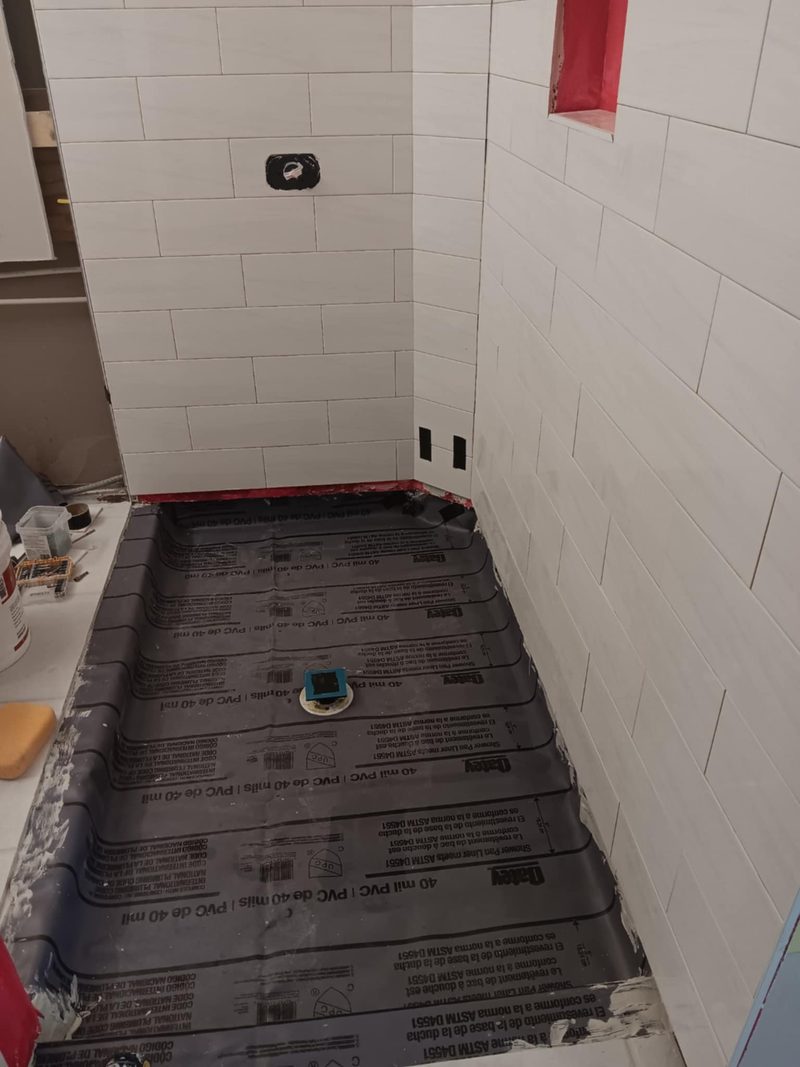 White subway tile shower with a pebble mosaic floor